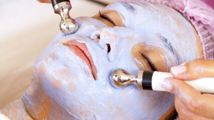 Woman in a spa salon on cosmetic procedures for facial care. Beautician makes medical procedures...