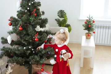 Toddler child with cochlear implant decorating christmas tree - deafness and innovating medical...