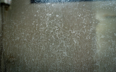 Scale stains on the glass partition in the bathroom.