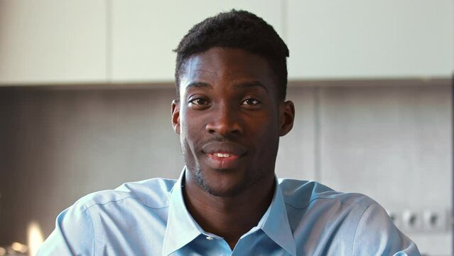 Young african american man looking at camera agreeing in conversation with colleague