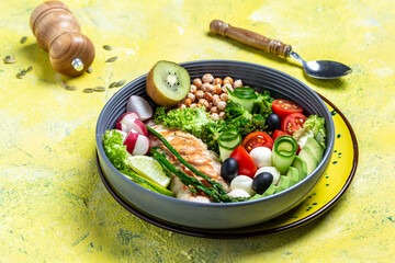 Buddha bowl dish with chicken fillet, avocado, asparagus, chickpeas, broccoli, radish, chicken, cucumber, tomatoes, olives, mozzarella. Detox and healthy superfoods concept, top view