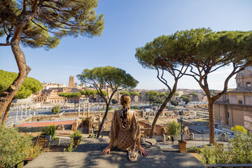 Naklejka na ściany i meble Woman enjoying beautiful view from above on the old centre of Rome. Traveling Italy on a summer day concept. Caucasian woman in dress and shawl in hair visiting Roman forum