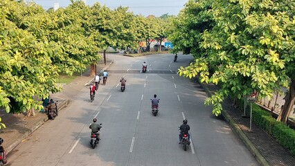 This is a situation of a street in Bintaro area, South Tangerang in Indonesia around 9am in the morning whereby  motorcycles bikers were passing by.