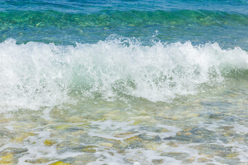 White waves on the beach. Sea coast on a sunny day. Summer vacation concept