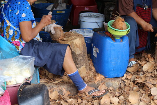 Farmers peeling dried coconuts
