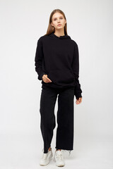 Portrait of young woman wearing black hoodie, isolated studio image on white background