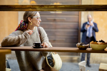 Woman drinking espresso coffee at traditional old style italian cafe on a bar at window on cozy...