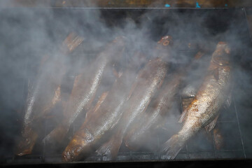 sea bass smoked in a smokehouse on oak chips. Fish cooked in smoke.