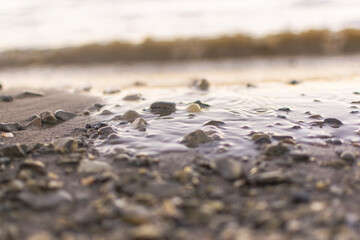 background sandy beach with waves and rocks