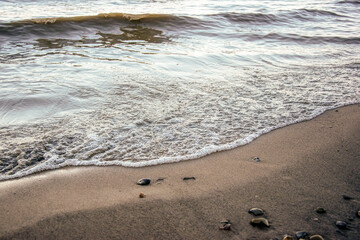 background sandy beach with waves and rocks