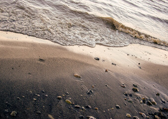 background sandy beach with waves and rocks