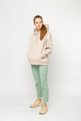 Girl in green cargo pants and beige hoodie isolated on white