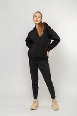 Girl in black cargo pants and black hoodie isolated on white