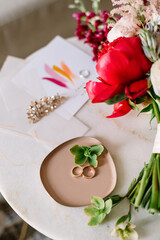 stylish details of the bride's morning, a bright bouquet and shoes, as well as invitation cards and wedding rings
