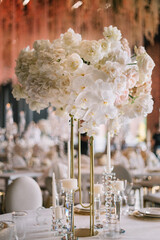 Dinner table rich decorated by candles and flowers. Luxury Wedding decor. Gorgeous concept
