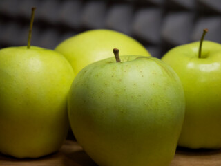 Four large apples, close-up. Fruit on a wooden surface.