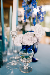 Festive wedding table. Stylish wedding table decoration and table setting in rustic style. Blue tablecloth. Vintage vase