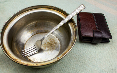 Hunger concept. Wallet and fork in an empty metal plate. Hunger and poverty. Food price rise...