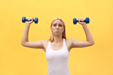 Fototapeta na wymiar Photo of serious young sports woman make exercises with dumbbells isolated over yellow wall background.