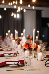 Autumn wedding table setting. Luxury stylish autumn wedding decor. Flowers and tableware on the wedding banquet. Styled romantic dinner in red color
