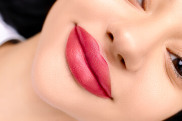 procedure after permanent make-up of the lips close-up lips of the model tattooed with red pigment
