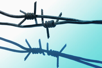 Close up barbed wire as a symbol of totalitarianism, authoritarianism and violent extremism. Horizontal image.