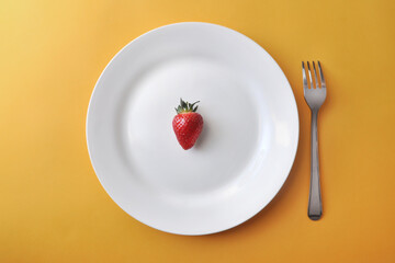 Ripe red strawberries on a white plate
