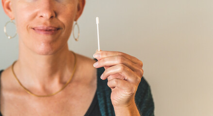 CLose shot of Woman holding covid 19 PCR test swab clean background