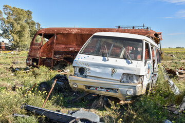 Old damaged cars in the junkyard. Car graveyard.