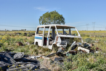 Abandoned school bus. Old damaged cars in the junkyard. Car graveyard.
