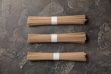 Buckwheat paste on a black cement background. Raw noodles. Ingredients for a gluten-free dish. Dried buckwheat soba noodles. Traditional Japanese food. Healthy food. Place to copy.