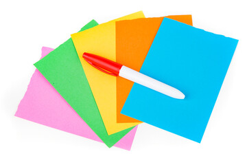 Permanent red marker on multicolored note pad papers isolated over white. Top down view