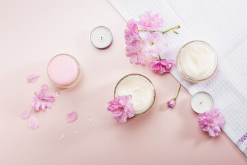 Body care cream and pink cherry blossoms..