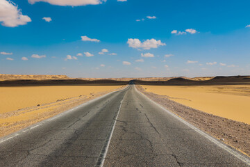 Fototapeta premium Asphalt Road View of the White Desert Protected Area in the Farafra Oasis, Egypt