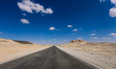 Fototapeta na wymiar Asphalt Road View of the White Desert Protected Area in the Farafra Oasis, Egypt