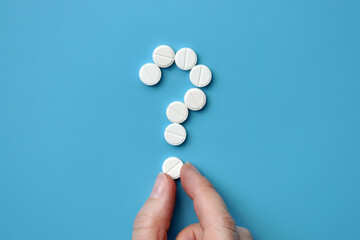 A question mark from pills. Symbol of questions on diagnosis and treatment