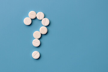 A question mark from pills. Symbol of questions on diagnosis and treatment