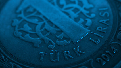 Fototapeta na wymiar Translation: Turkish lira. Fragment of Turkish 1 one lira coin close-up. National currency of Turkey. Blue tinted money wallpaper. Background for news about economy or finance. Macro