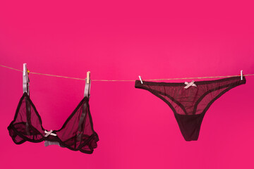 Lace panties. The sexy lingerie isolated on the pink red background. Thong bikini panties, black...