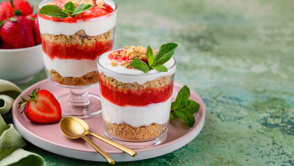 Crispy creamy strawberry trifle. Delicious summer dessert of shortbread crumbs, yogurt quark cream and strawberries. Selective focus. Copy space
