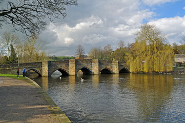Fototapeta na wymiar A view along the river Wye in picturesque Bakewell Derbyshire showing the old multi arched bridge