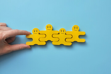 A group of wooden smiling men. Symbol of a group of like-minded people