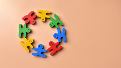 A group of wooden men holding hands. A symbol of teamwork or friendship between different people