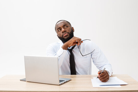 thoughtful young african american businessman working on laptop computer