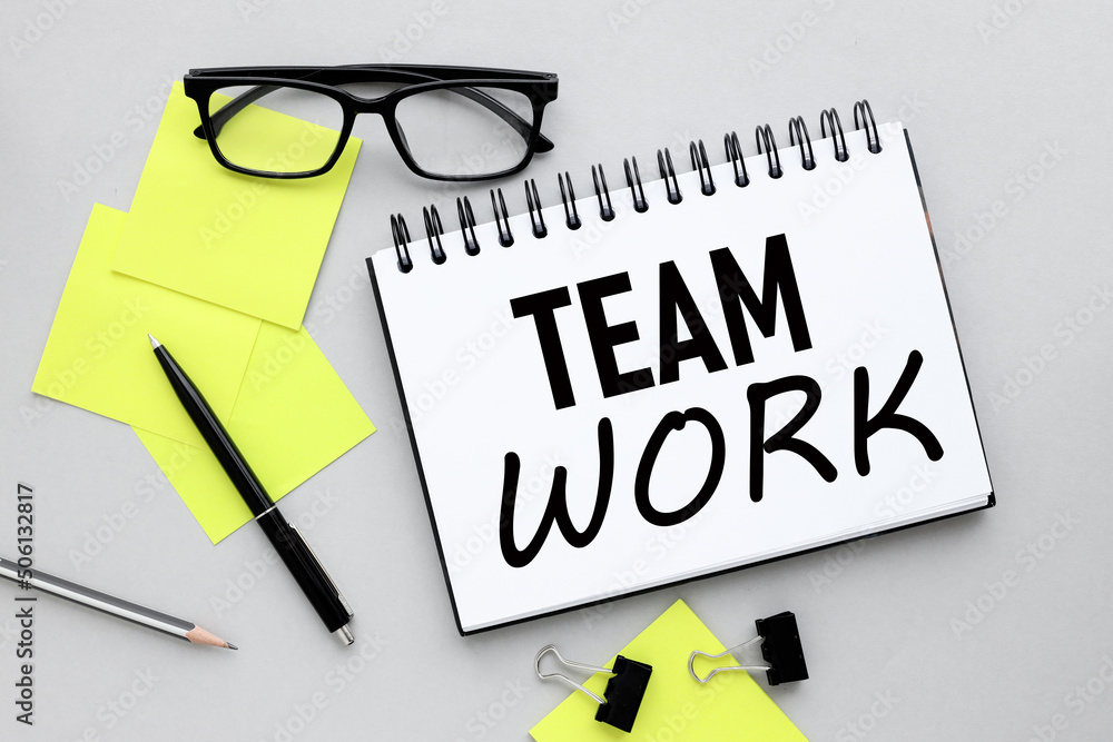 Poster team work. stickers and notepad on a gray background. text on notebook.