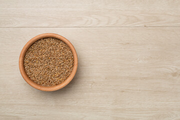 Wholegrain spelt farro in bowl on wooden background. Top view