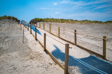 Beach access entrance hill with a guardrail and blue rubber roller