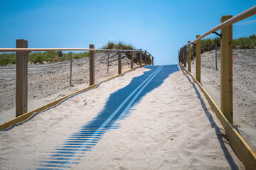 Beach uphill footpath with the blue rubber roller and wooden guardrails on Cape Cod in Massachusetts