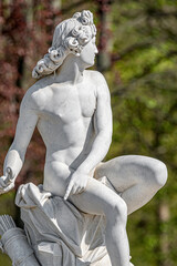 Old statue of Italian Renaissance and Rococo era young hunter in park of Potsdam, Germany, details,...