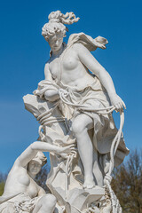 Old statue in the city park of two sensual Renaissance Era women catching a child by fishing net...